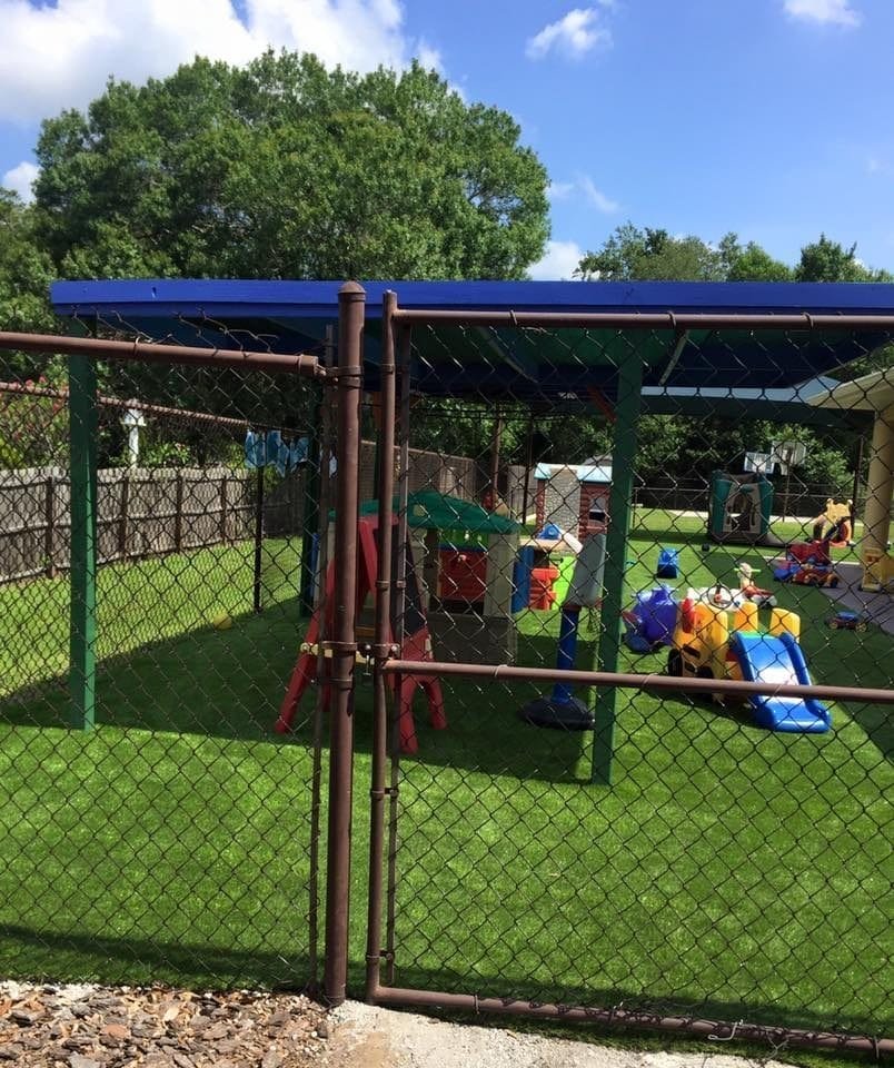 Children playing area with slides and swings under blue shade cloth.