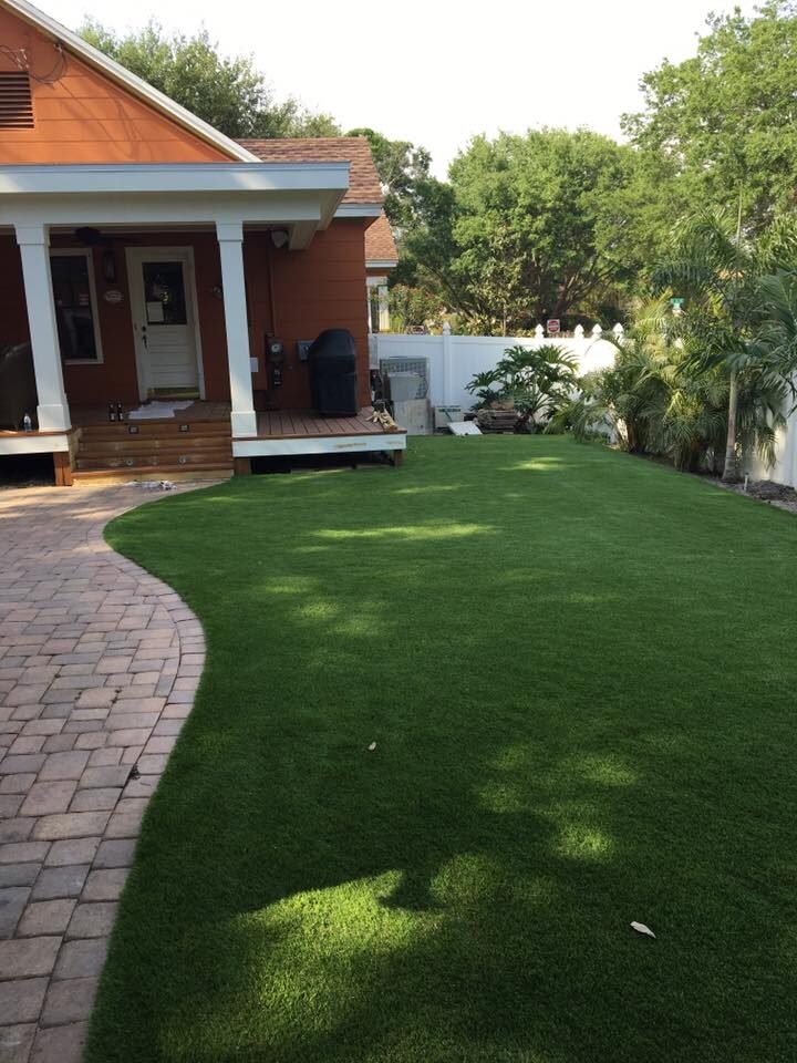 Well-maintained lawn with a curved brick pathway leading to a porch.