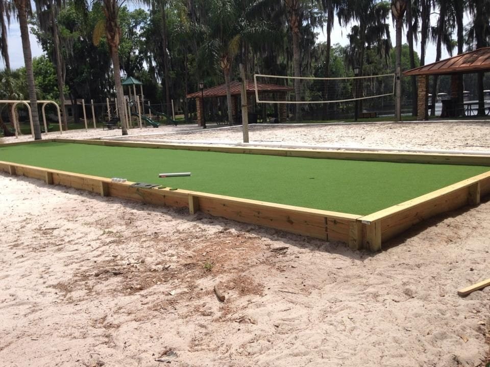 Outdoor sand volleyball court and bocce ball court in a natural setting.