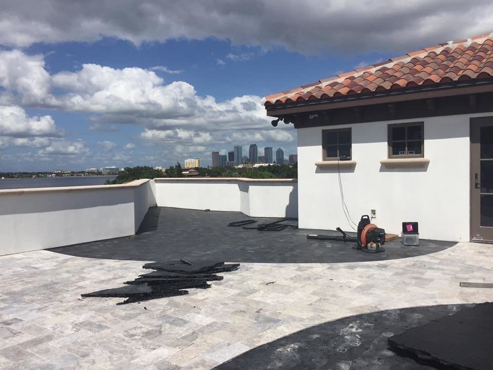 Rooftop terrace with city skyline under a partly cloudy sky.