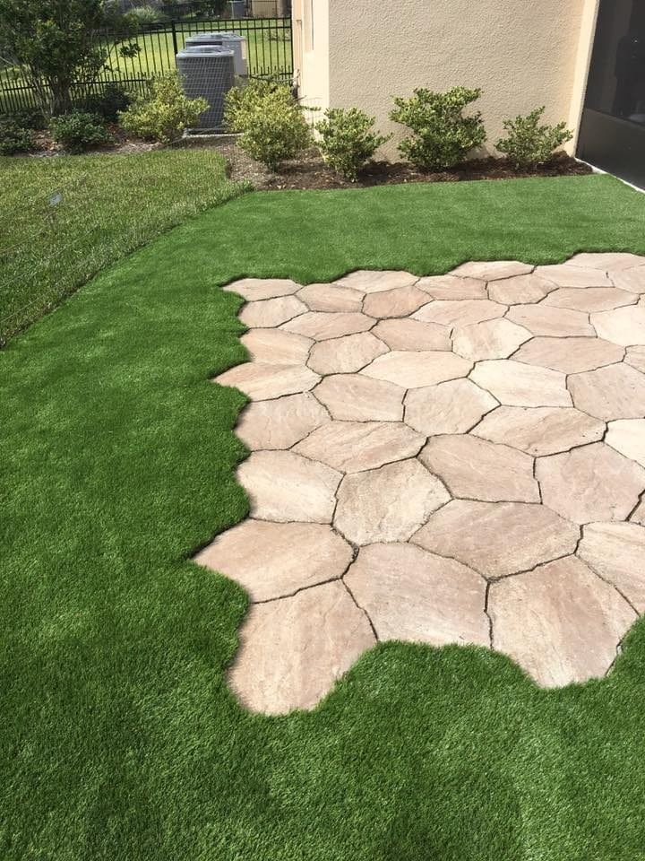 A well-maintained lawn with irregular stone pavers creating a natural pathway.