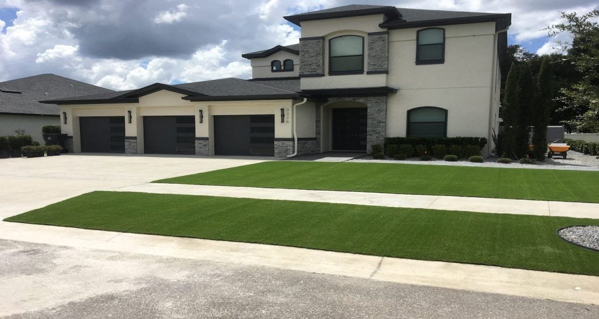 Modern two-story house with a manicured lawn and three-car garage.