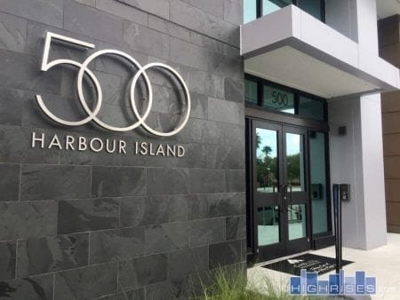 Modern building entrance with Harbour Island logo on stone wall.