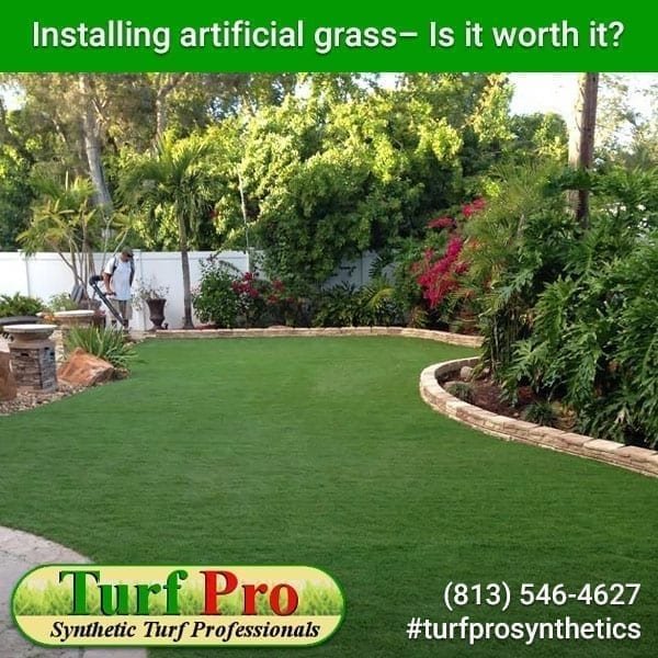 Artificial grass installed in a backyard with landscaping.