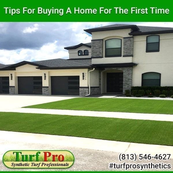 A modern house with a well-kept lawn and a driveway under a clear sky.