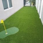 A small indoor putting green with a flag and artificial turf.