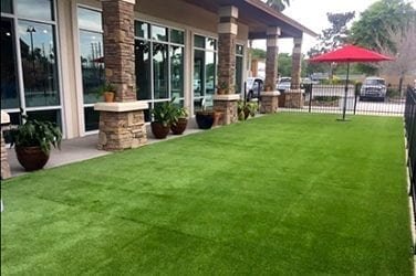 Well-maintained artificial grass lawn outside a modern house.
