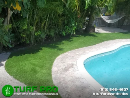 A freshly edged lawn with a clean concrete pool border and clear blue water.
