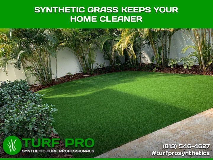 Synthetic grass lawn in a backyard with trees and plants, promoting cleanliness.