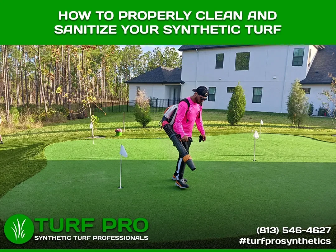 Person cleaning synthetic turf with specialized equipment on a putting green.