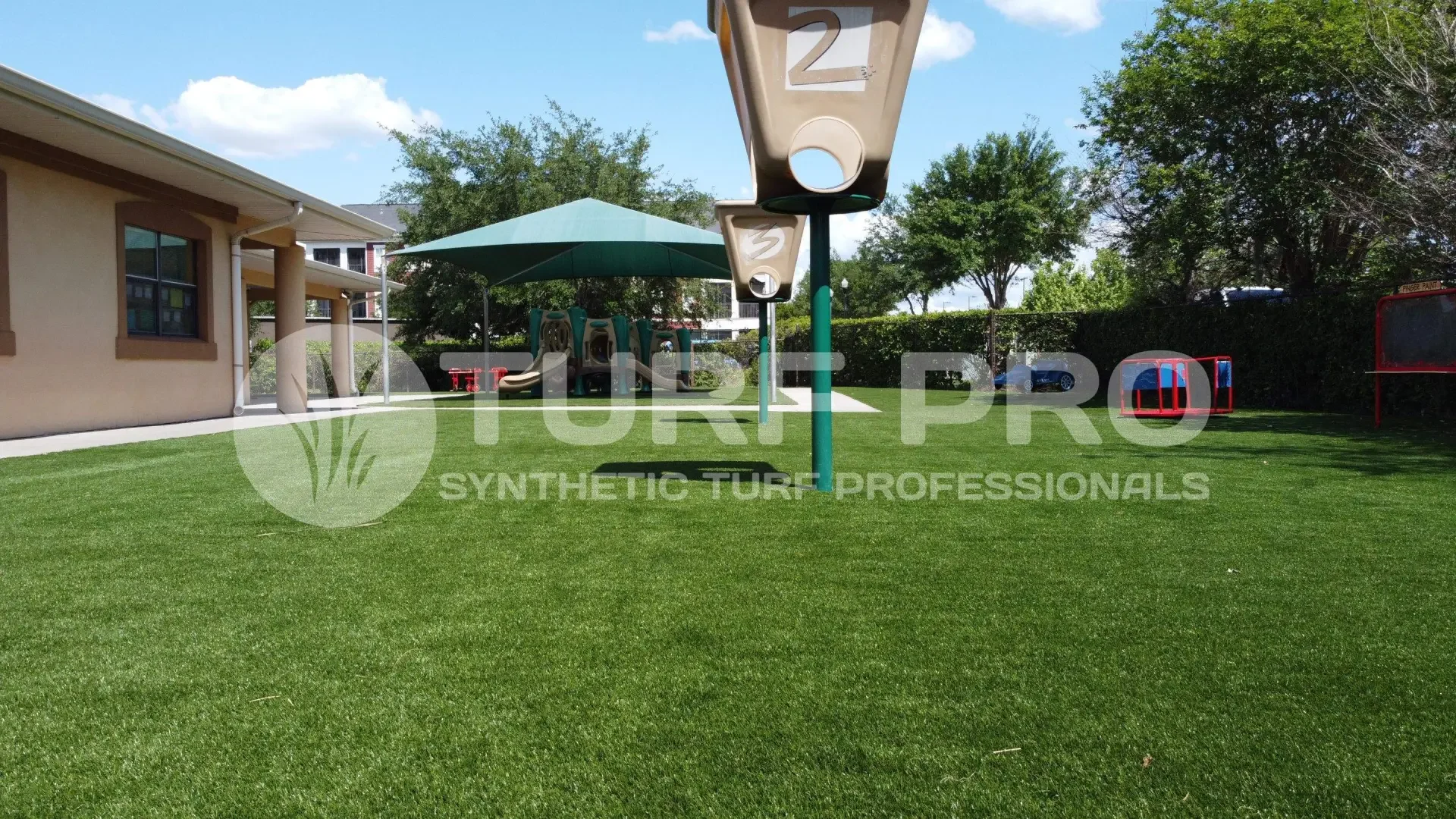 Artificial turf golf putting green in a backyard with a gazebo.