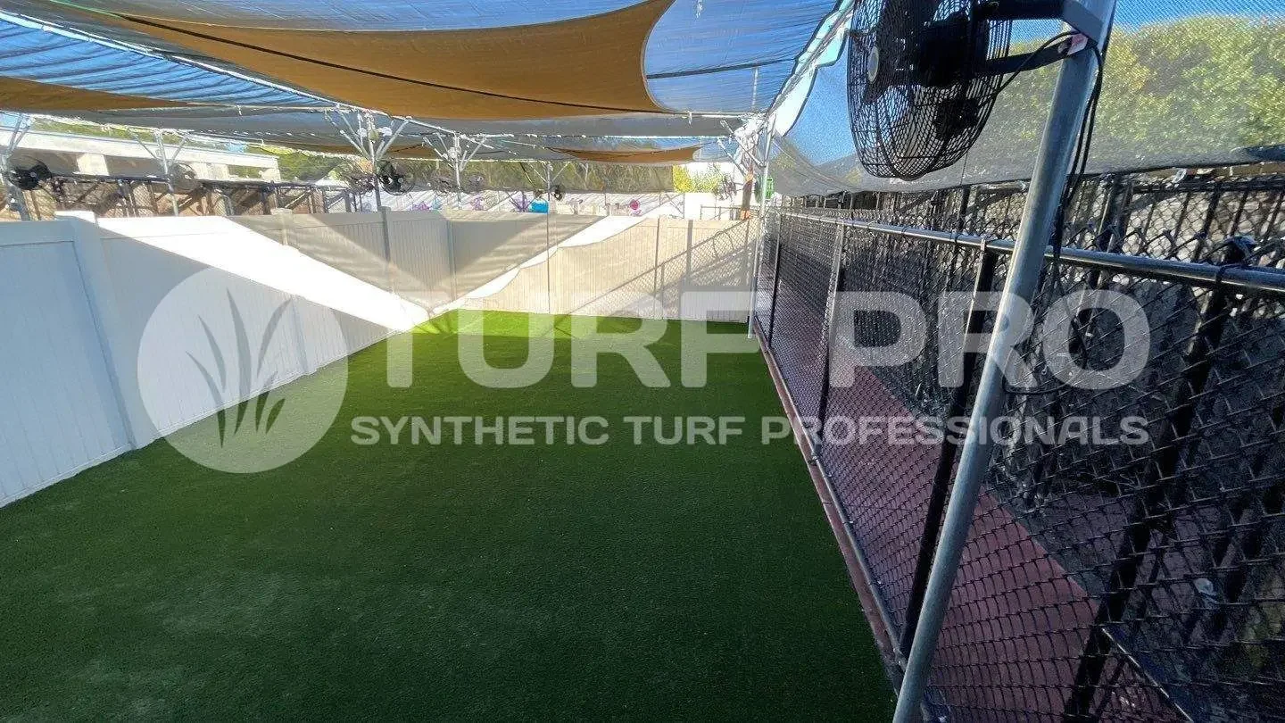 Covered synthetic turf area with netting and shade sails.