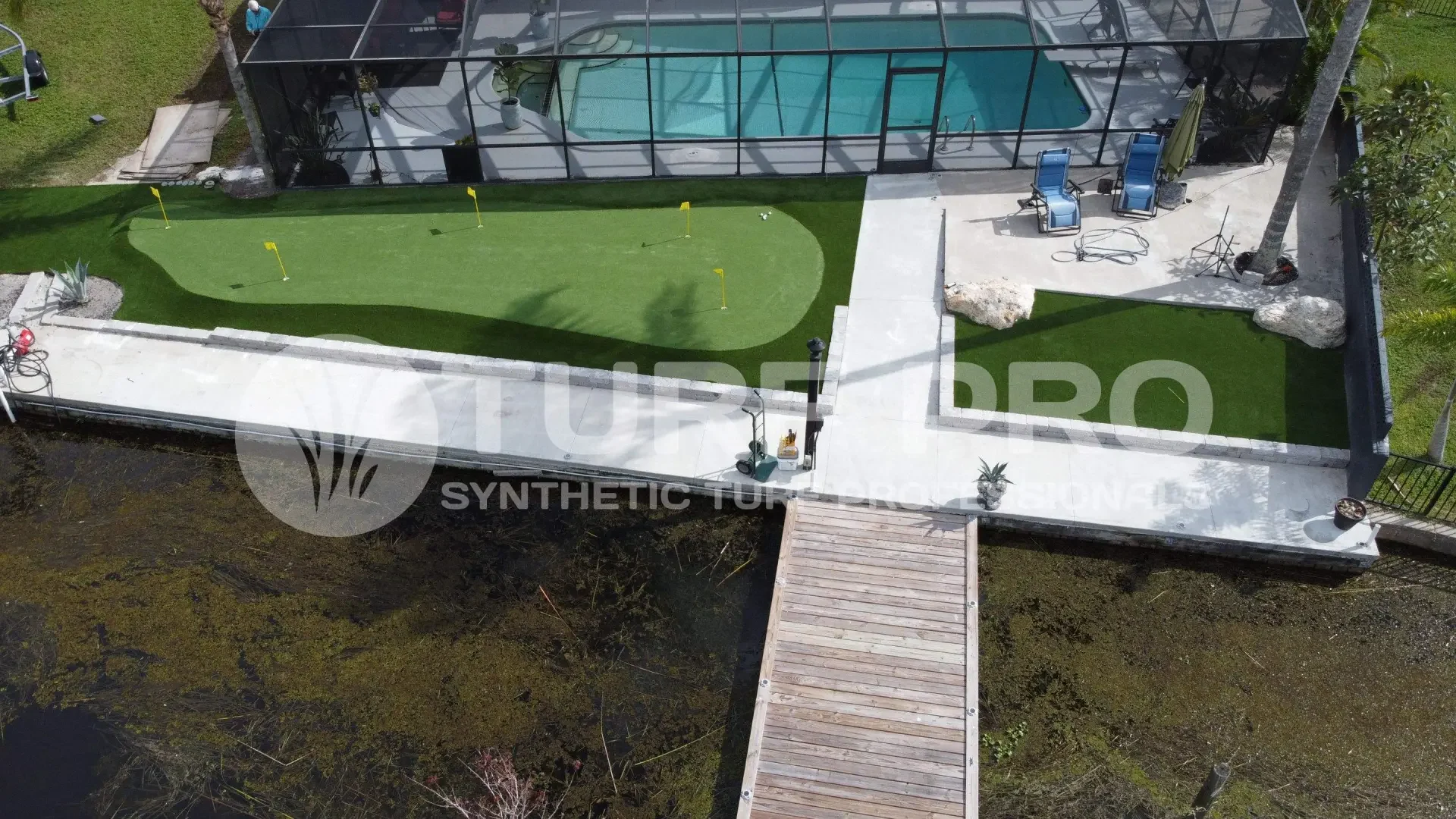 Boat docked beside a wooden pier on clear water.