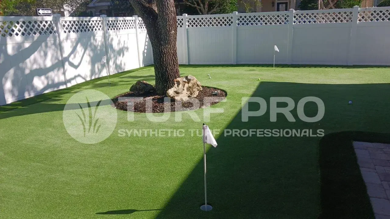 Backyard putting green with synthetic turf and a golf hole.