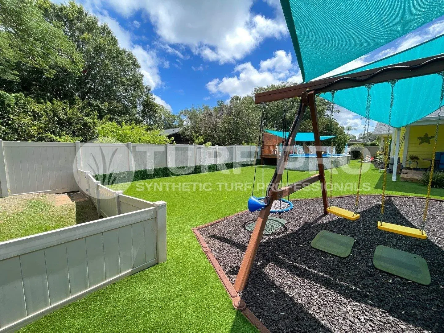 A vibrant outdoor playground with swings and a playhouse under a blue sky.