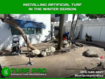 Workers installing artificial turf outdoors during winter season.